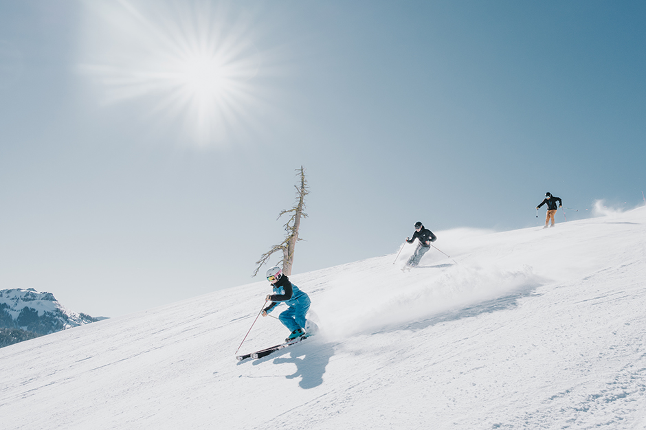 Group of women skiers improving their skills with a friendly instructor on a groomed run at Sugar Bowl Ski Resort