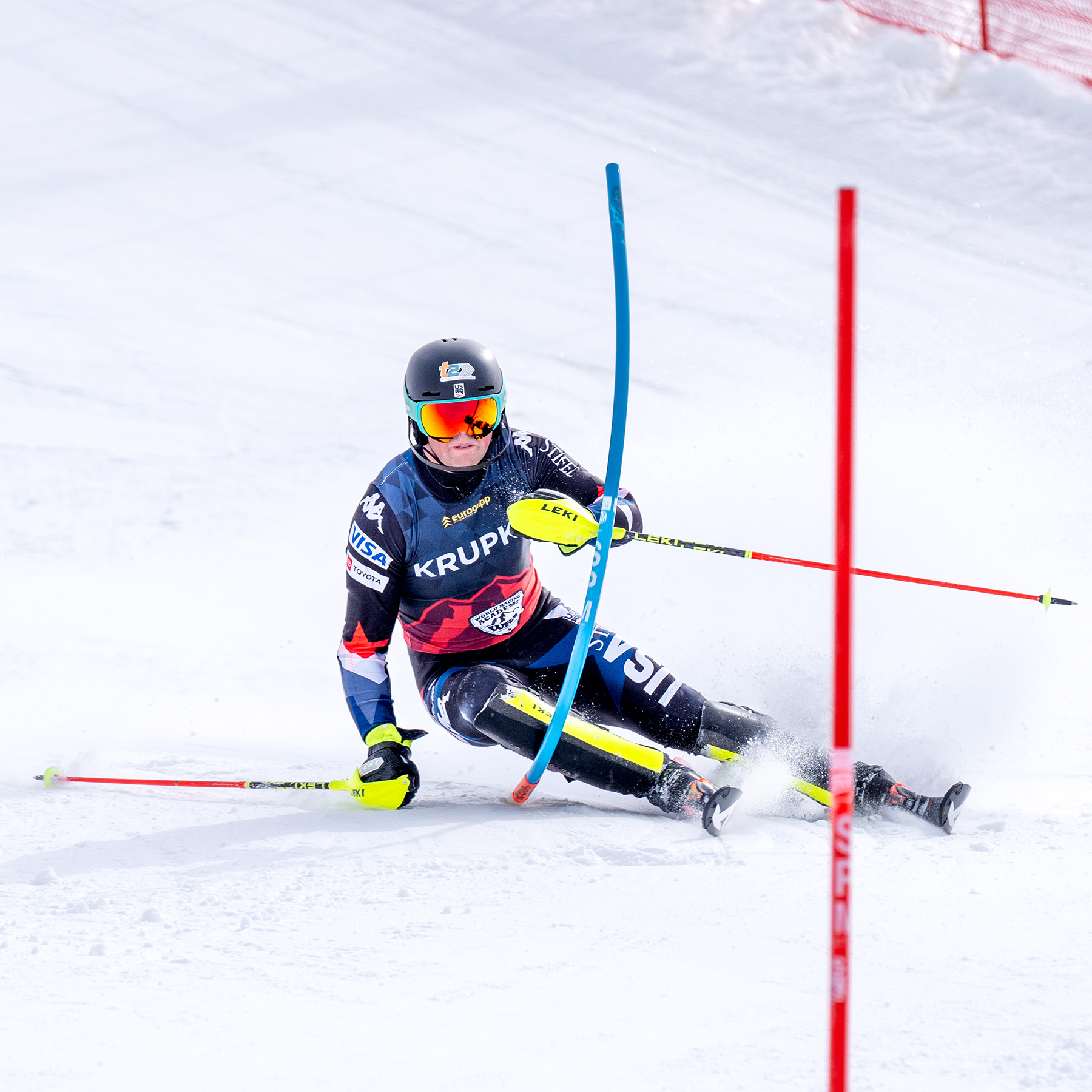 Ski racer making a hard left turn making contact with a Sugar Bowl race gate.