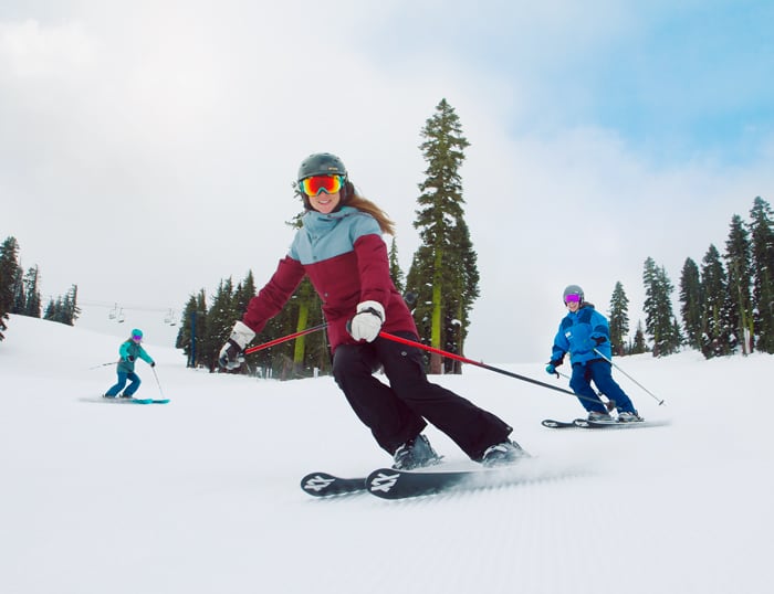 Group of women skiers improving their skills with a friendly instructor on a groomed run at Sugar Bowl Ski Resort