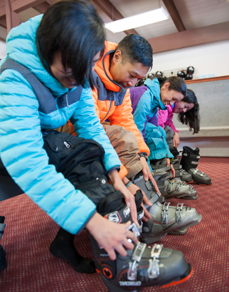 Family putting on their rental ski boots.