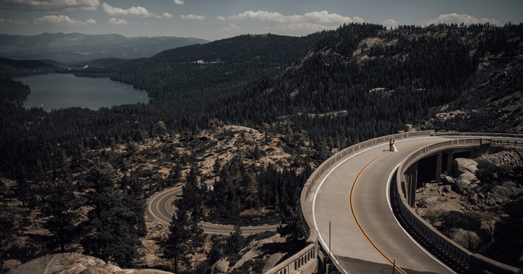 A couple posing on Route Old 40 with a view of Donner Lake in the background