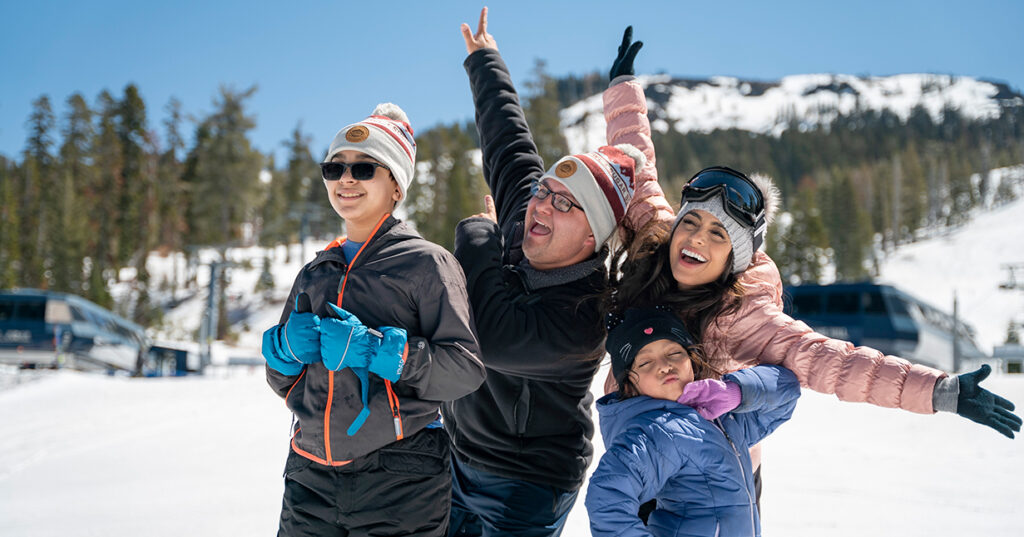 Family posing for a photo in front of the mountain