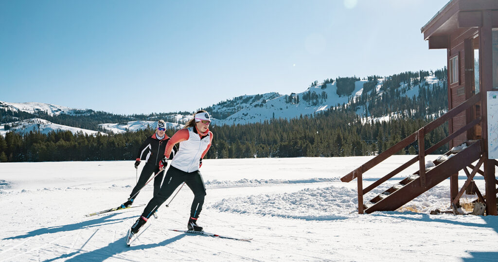 Two skate skiers glide through Van Norden Meadow on a sunny day