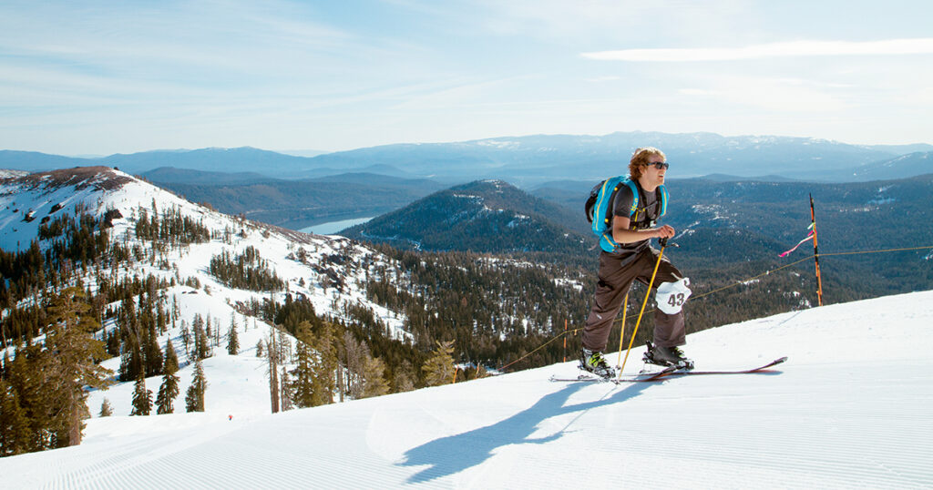 Skinning uphill on a clear morning with a view of Donner Lake in the background.