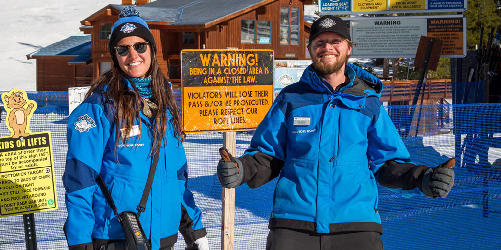 2 ski resort employees smiling