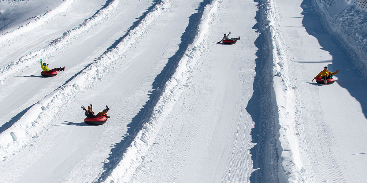 A group of friends tubing at Sugar Rush, Tahoe's best snow tubing park.